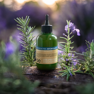 immagine del prodotto dell'emulsione peel deforforante ambientata in sfondo con rosmarino e lavanda